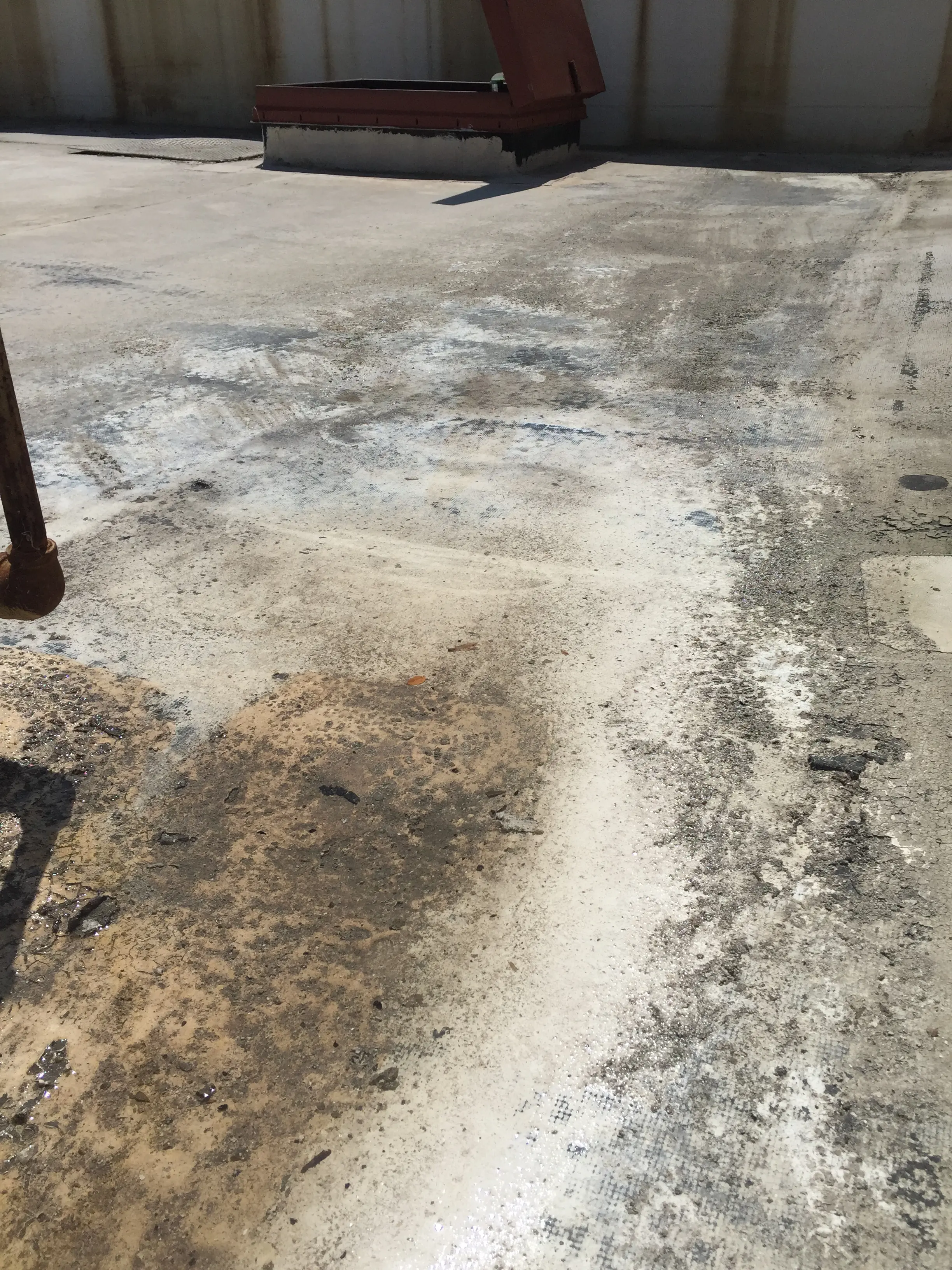 Ponding water area on flat roof showing soot and sediment accumulation